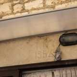 ...un altro poco pi� avanti che sopra la porta reca ancora l�iscrizione �1954�...